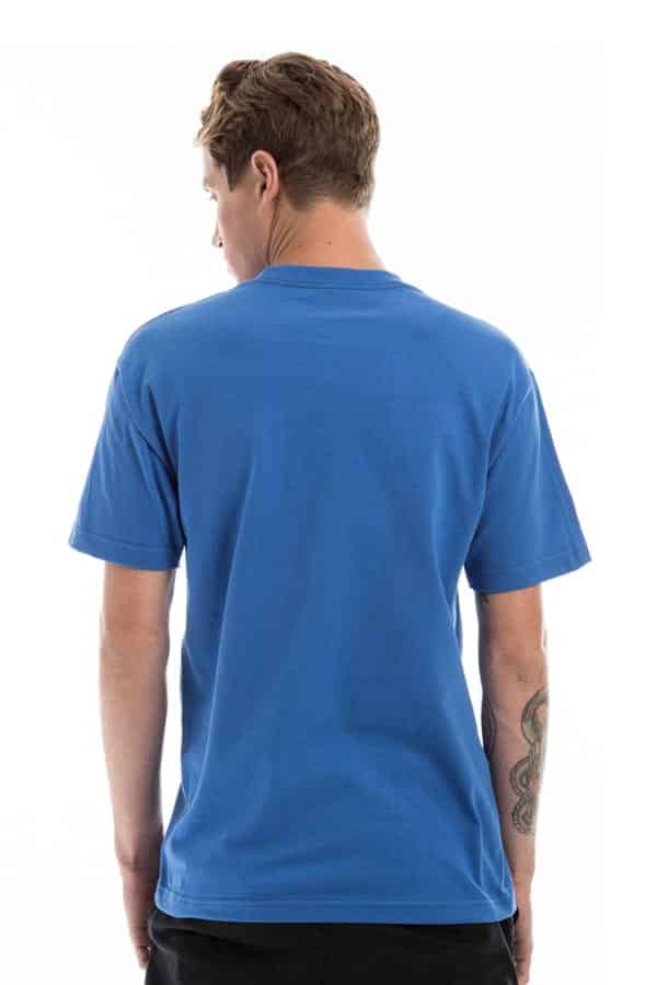 Man wearing a blue T-shirt facing away, with tattoo on his left arm against a white background.
