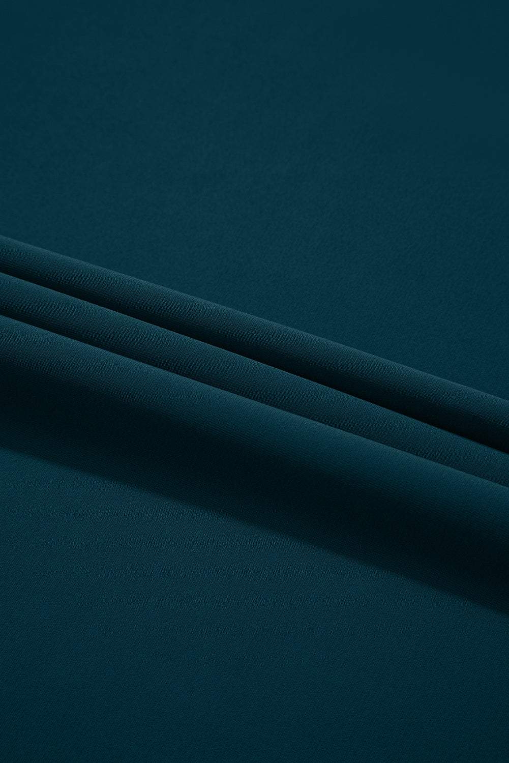 Dark teal fabric, smooth texture, with two neat horizontal folds creating subtle shadows.