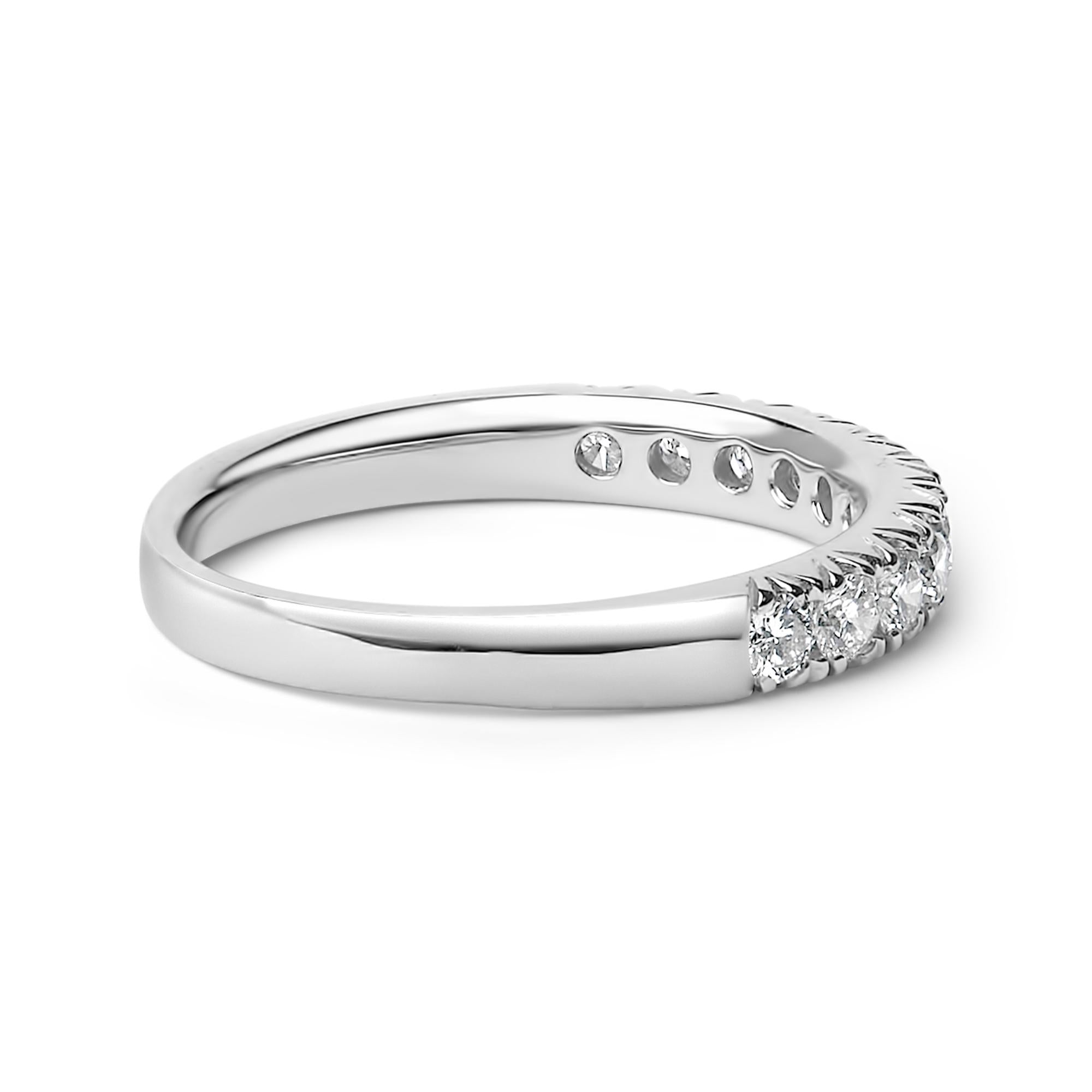 Silver ring with small, sparkling diamonds set on the top half against a white background.
