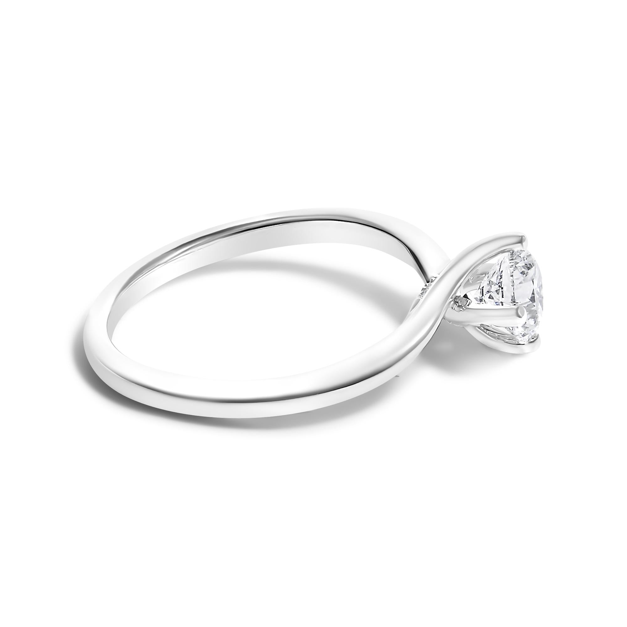 Silver ring with a twisted band, holding a round, clear gemstone.