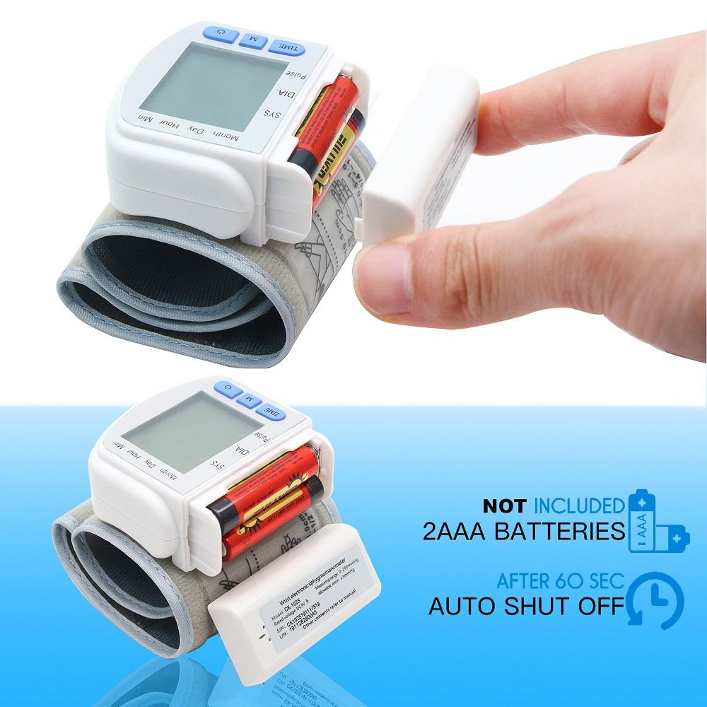 Digital wrist blood pressure monitor with open battery case, 2 AAA batteries, on blue background.