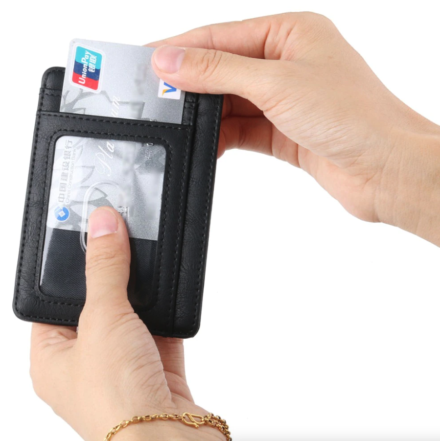 Hands holding a black cardholder with a transparent window, inserting a silver card.