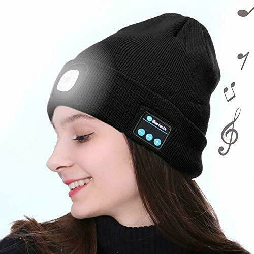 Woman in black Bluetooth beanie with control panel, smiling, musical notes in the background.