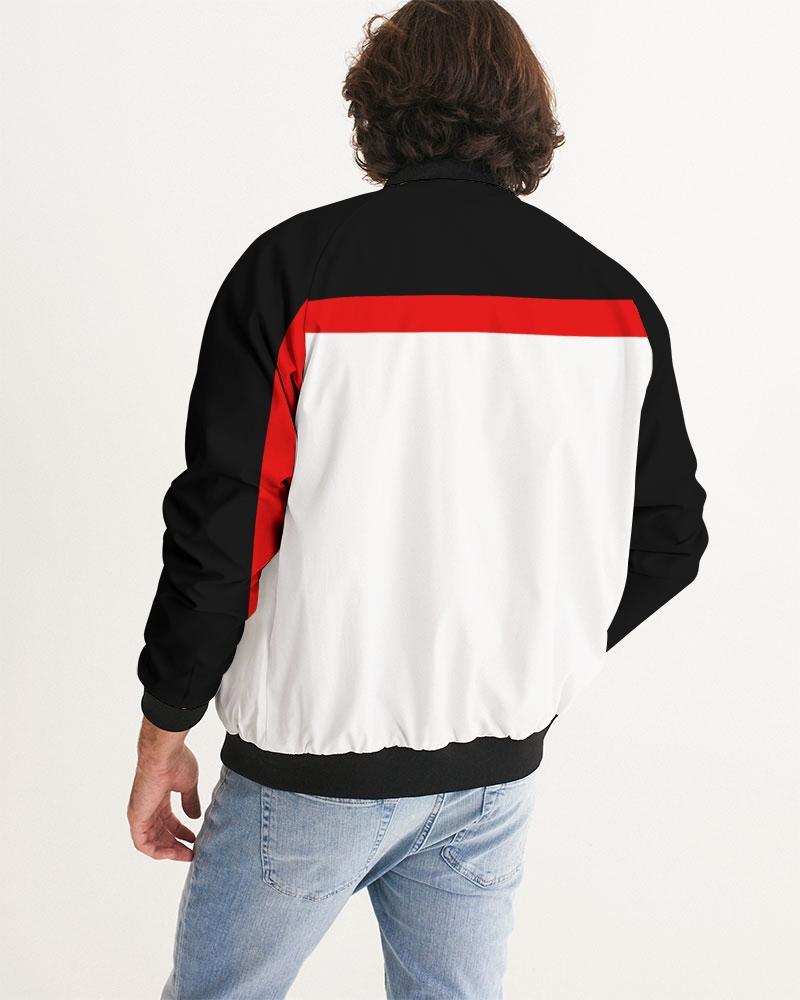 Back view of a person wearing a black, white, and red jacket with blue jeans.