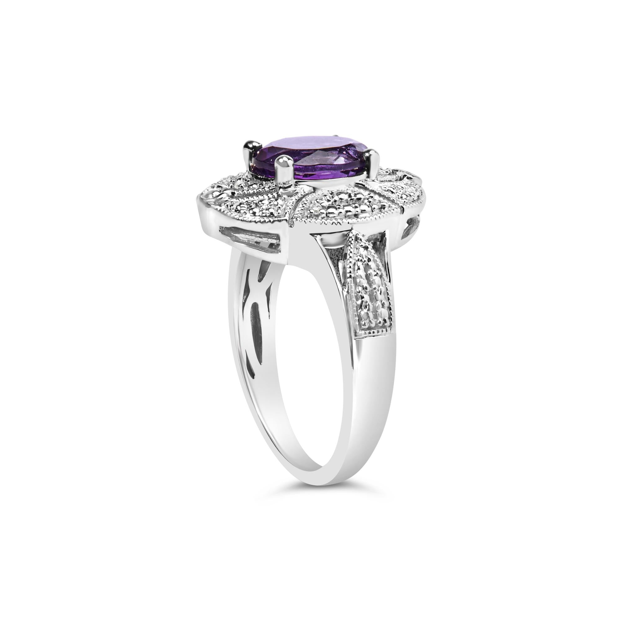 Silver ring with an oval purple gemstone, surrounded by sparkling clear stones and intricate details.