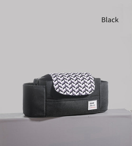 Black bag with white chevron-patterned flap on a gray surface, labeled "love."