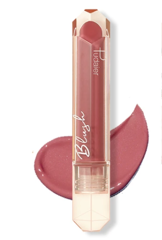 Pink lipstick with a faceted cap, laying on a light pink smudge background.
