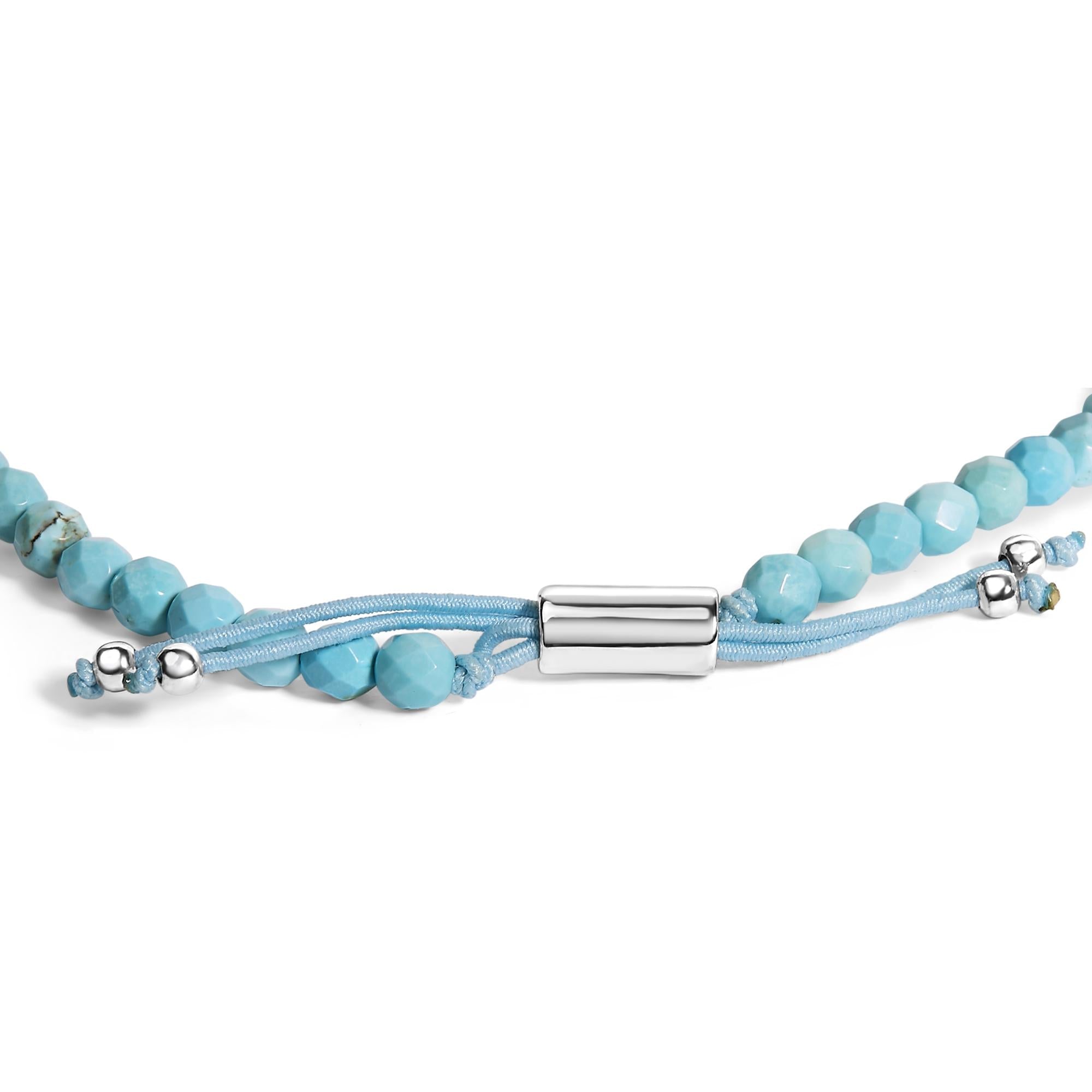 Turquoise beaded necklace with silver clasp and light blue cord against a white background.