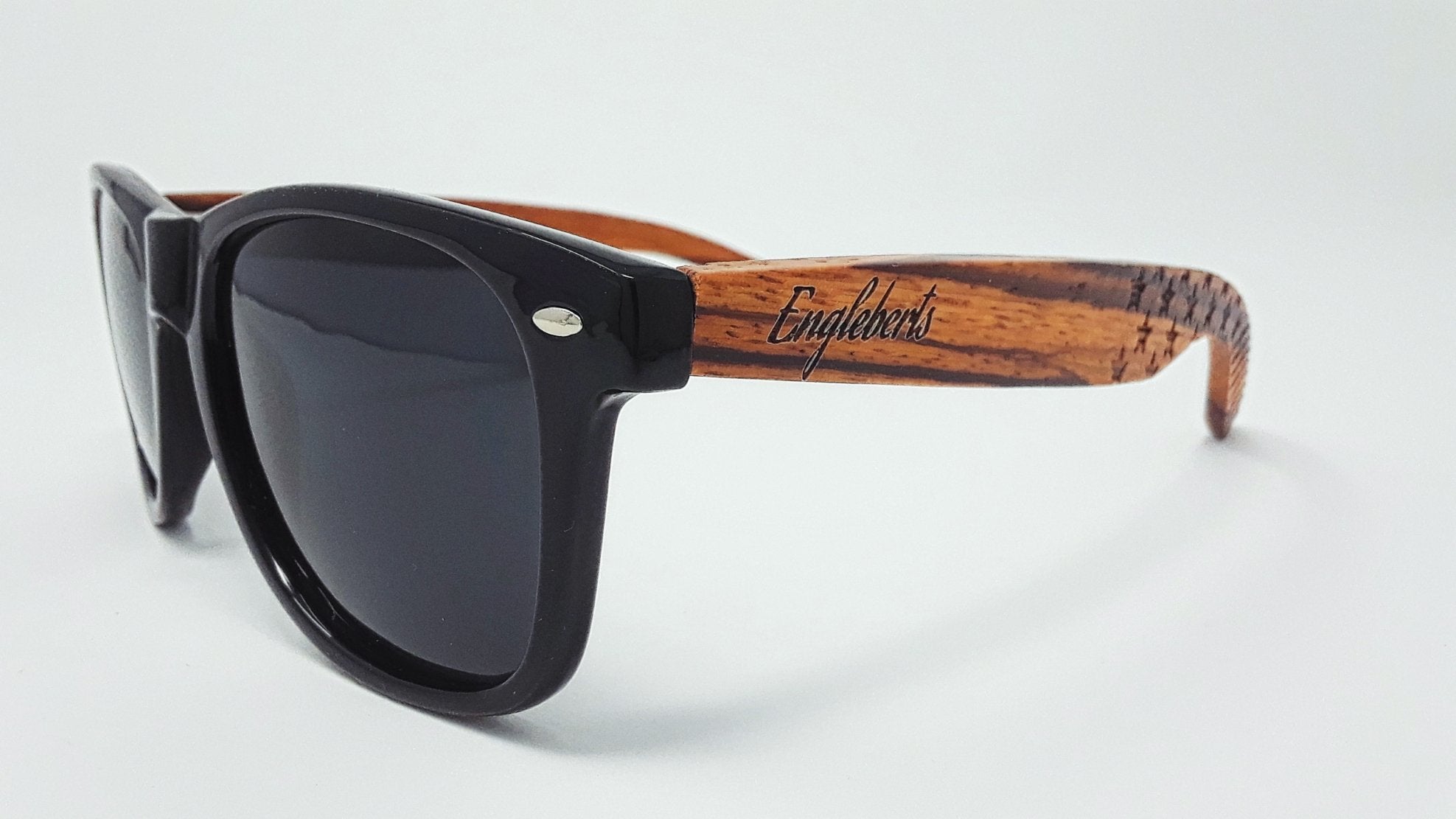 Black sunglasses with dark lenses and brown wood-patterned arms on a white background.
