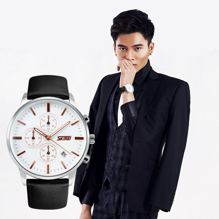 Man in black suit wearing a silver watch; large close-up of watch with white face and black strap.