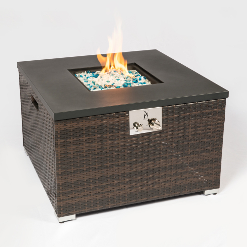 Square wicker fire pit with black top, blue and white stones, and bright orange flames.