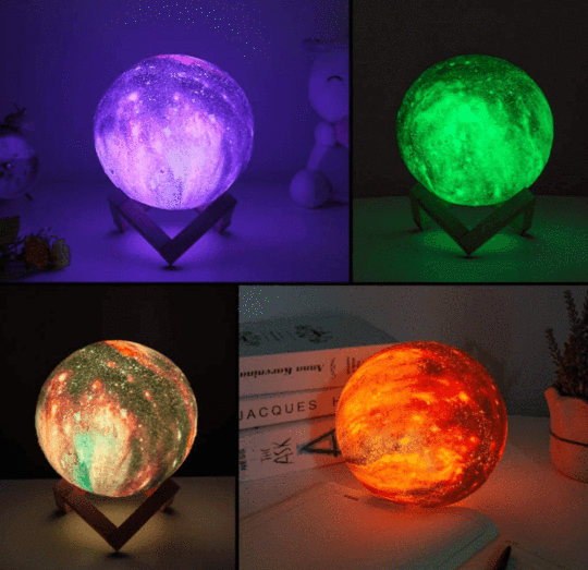 Four spherical lamps glow in purple, green, mixed tones, and orange, each on a wooden stand.