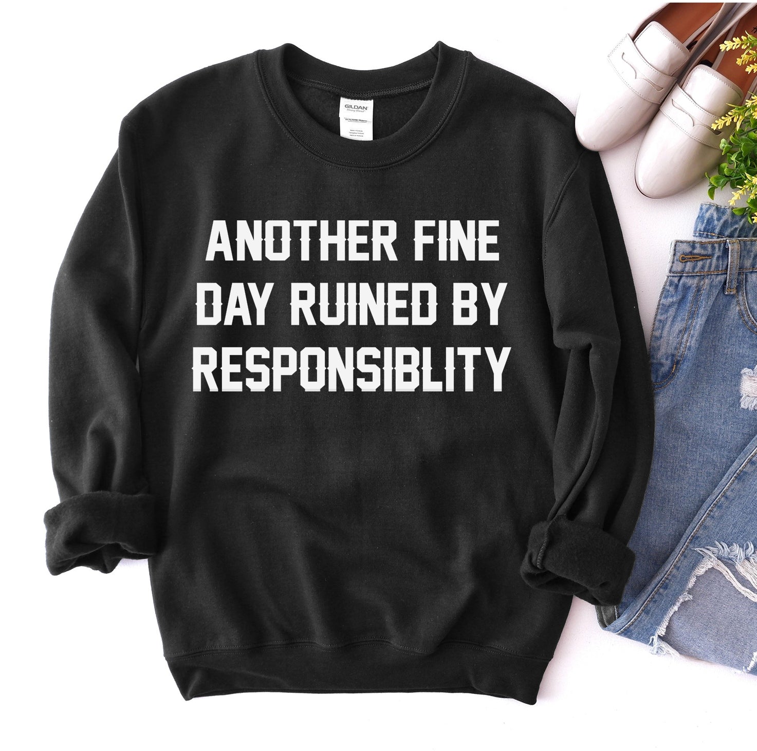 Black sweatshirt with white text: “Another fine day ruined by responsibility.”