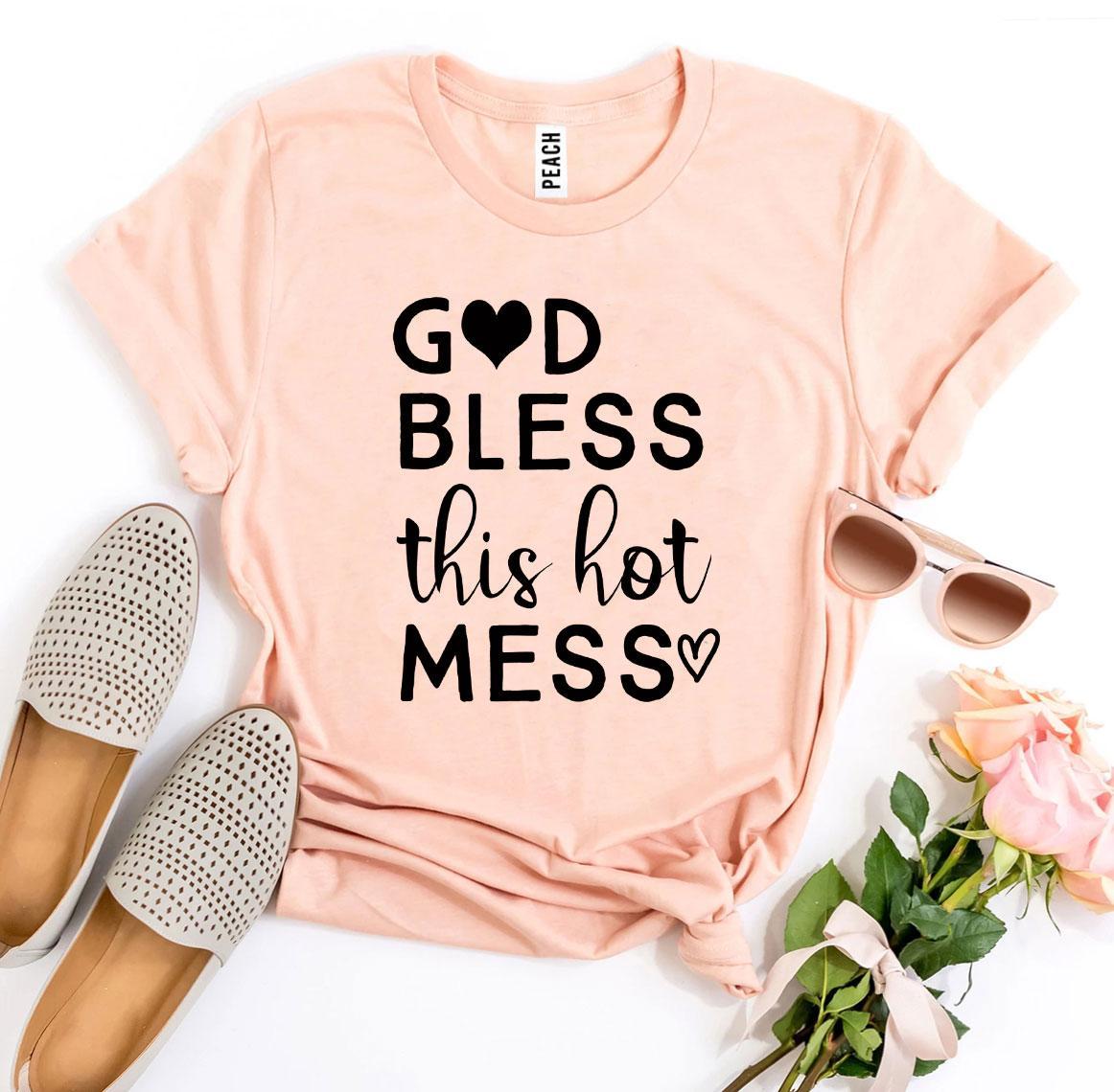 Peach T-shirt with black text "God Bless This Hot Mess," paired with sunglasses, shoes, and pink roses.
