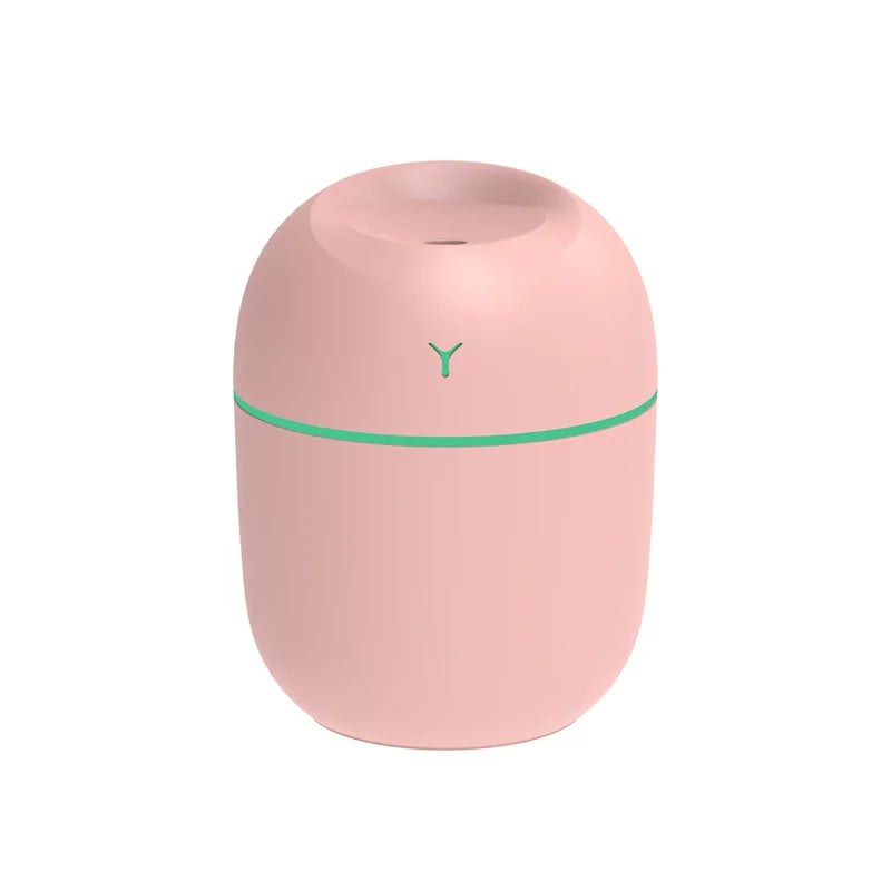 Pink cylindrical humidifier with a teal stripe and a small opening on top.