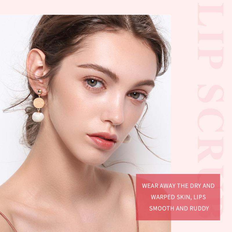 A woman with natural makeup and statement earrings, surrounded by soft pink text.