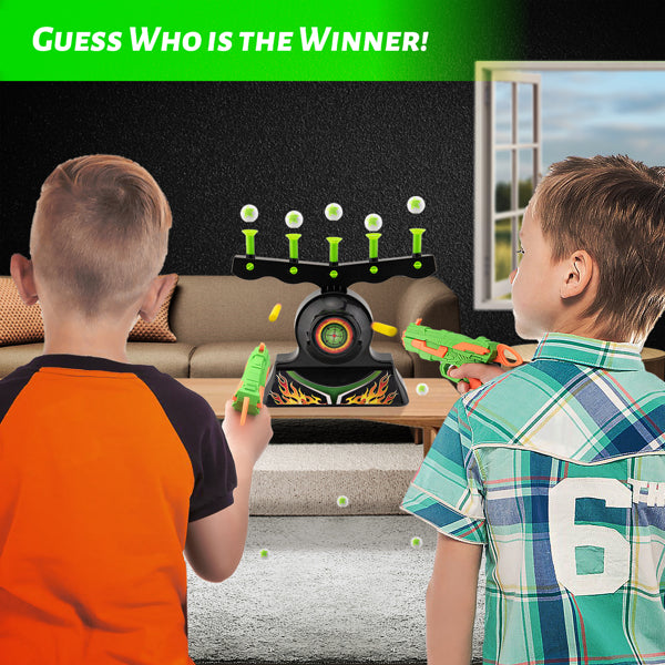 Two boys aiming green toy guns at a target in a living room, with a green "Guess Who is the Winner!" text.