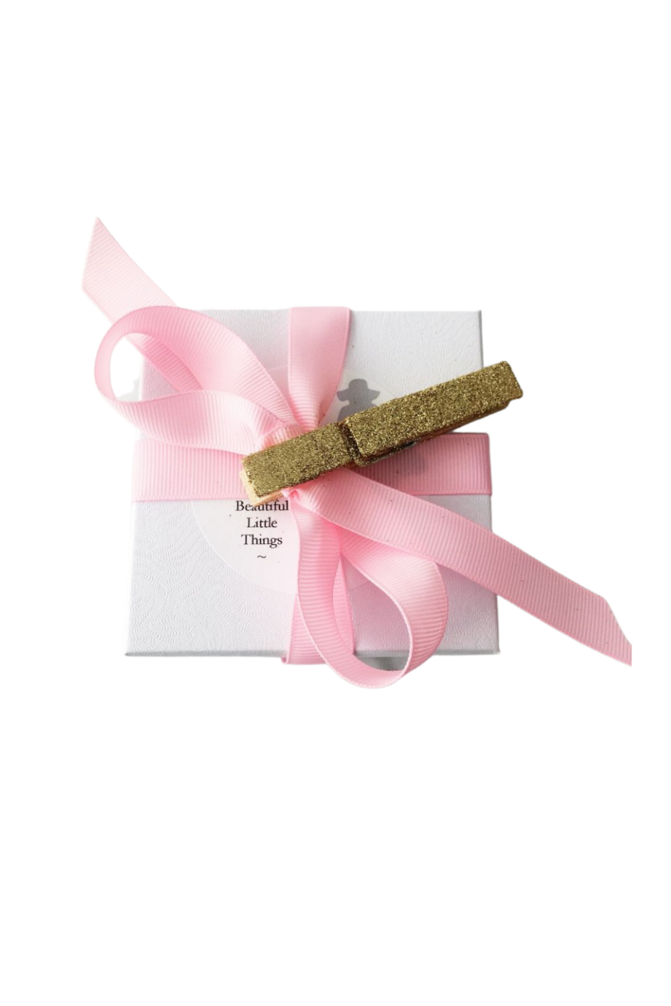 White gift box with pink ribbon and gold glitter clip on top.
