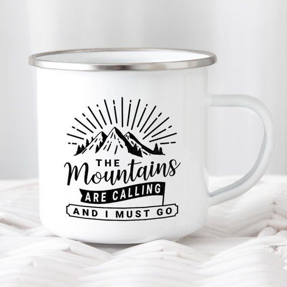 White metal mug with mountain design and text: "The mountains are calling and I must go."