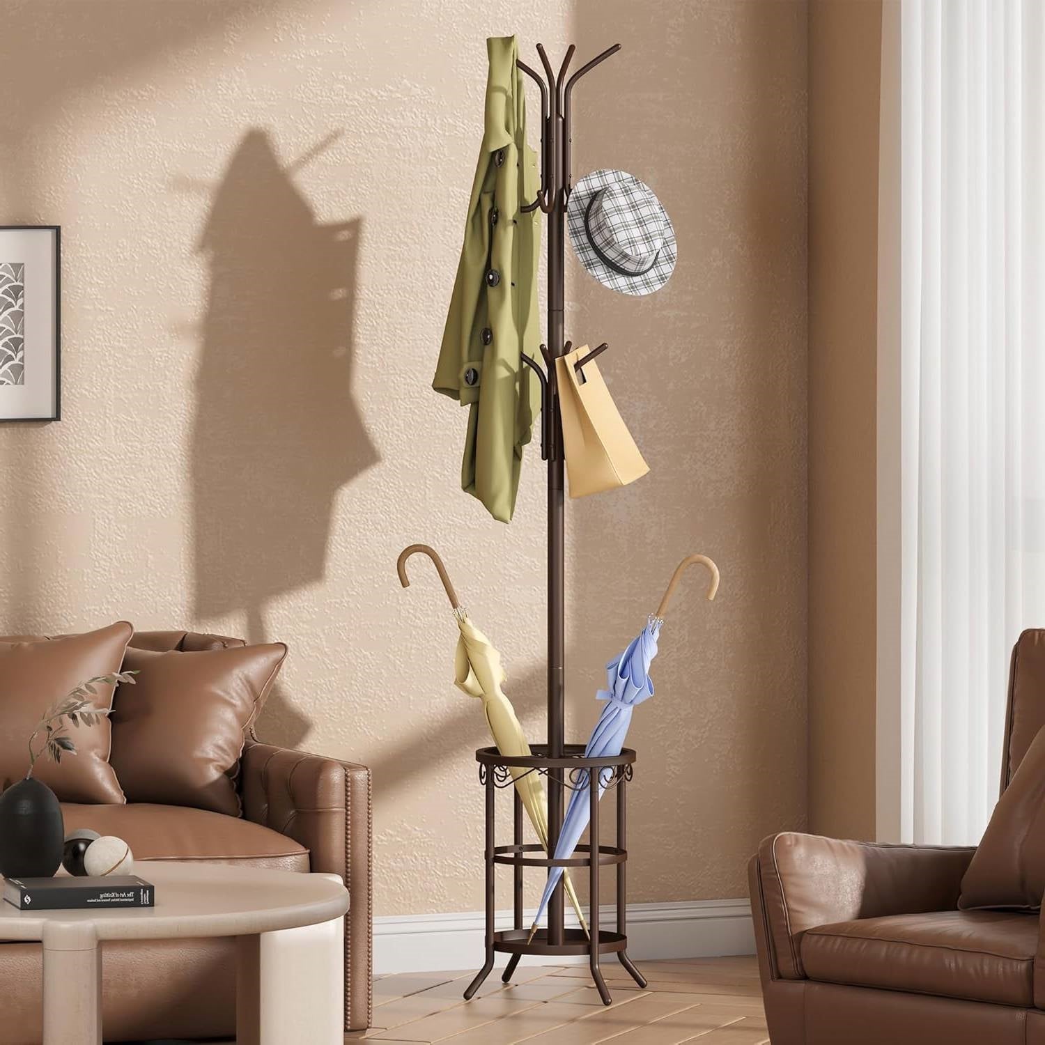 Coat rack with green coat, plaid hat, and umbrellas beside a brown sofa in a beige room.