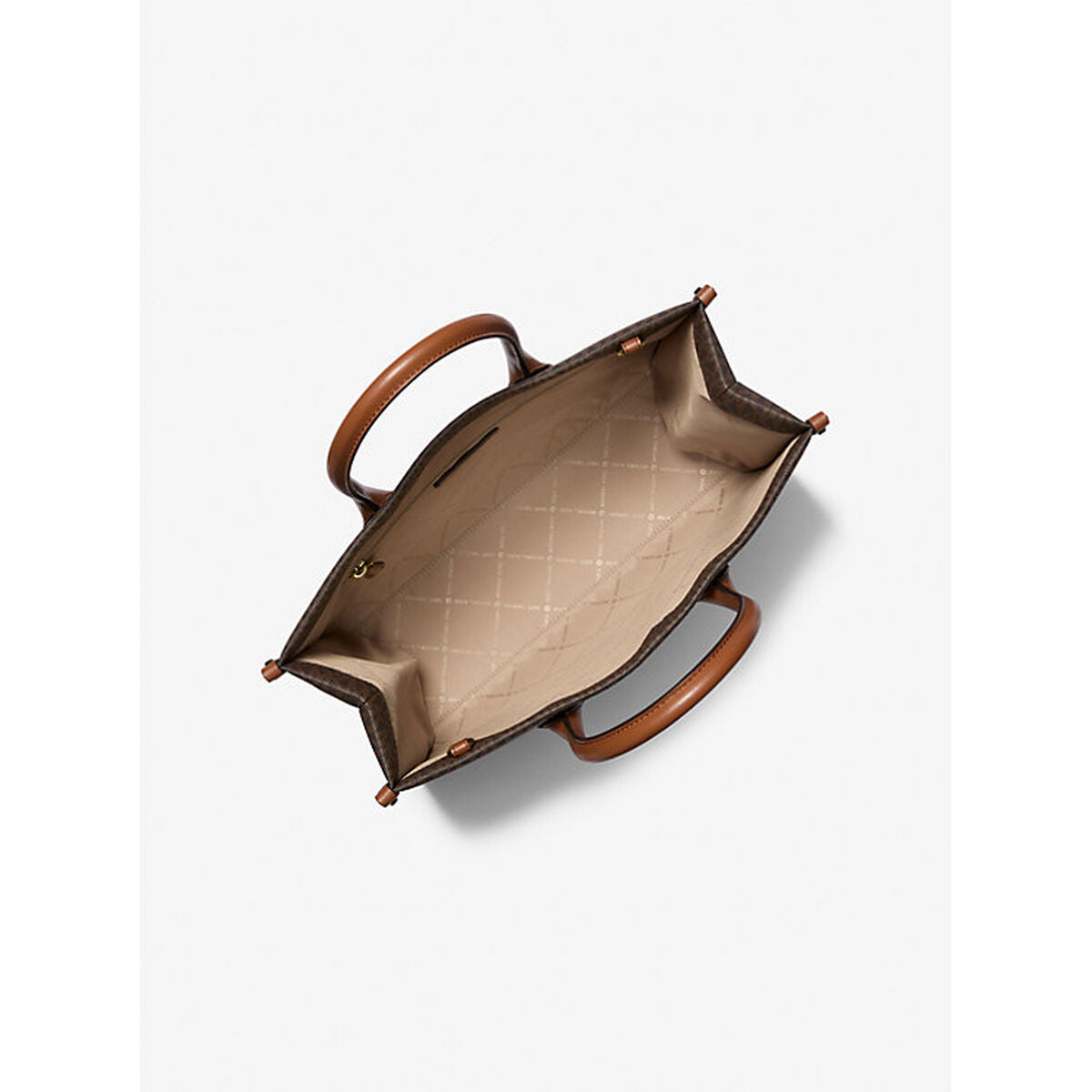 Top view of an open handbag with brown handles, quilted beige interior, and dark patterned exterior.