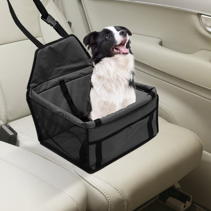 Dog in a black pet car seat with beige interior, looking up and panting.