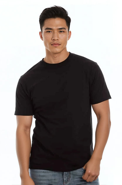 Man in black t-shirt and jeans stands against white background, looking forward.