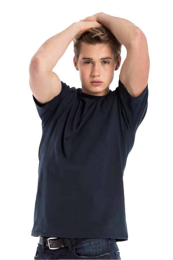 Young person in a navy T-shirt, arms raised over head, on a white background.