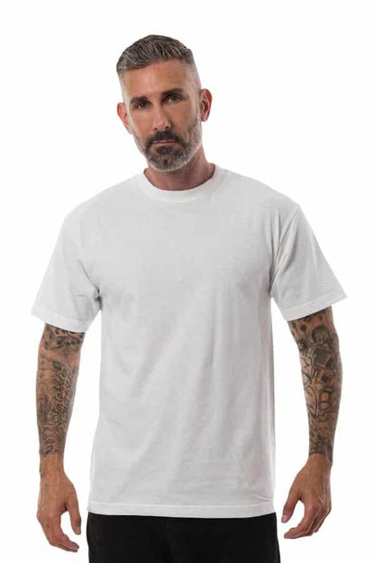 Man with a beard wearing a plain white T-shirt and black pants, with tattooed arms, on a white background.