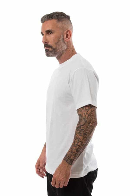 Man in white t-shirt with tattooed arm, side view, against white background.