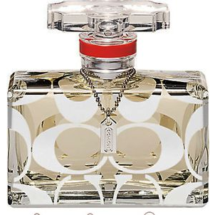 Clear rectangular perfume bottle with white patterns, red band, and silver chain around the neck.