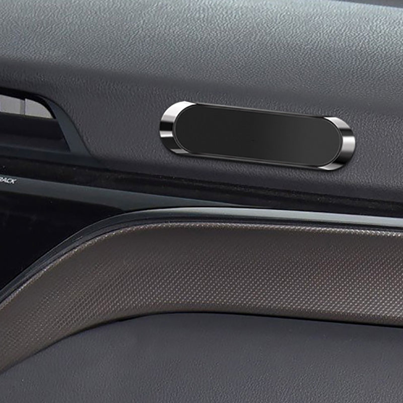 Dark car interior with a black oval-shaped magnetic holder and textured surfaces.