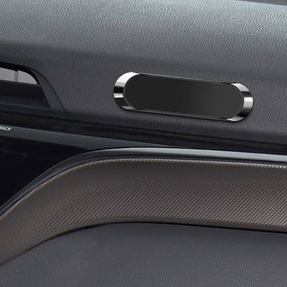 Dark car interior with a black oval-shaped magnetic holder and textured surfaces.