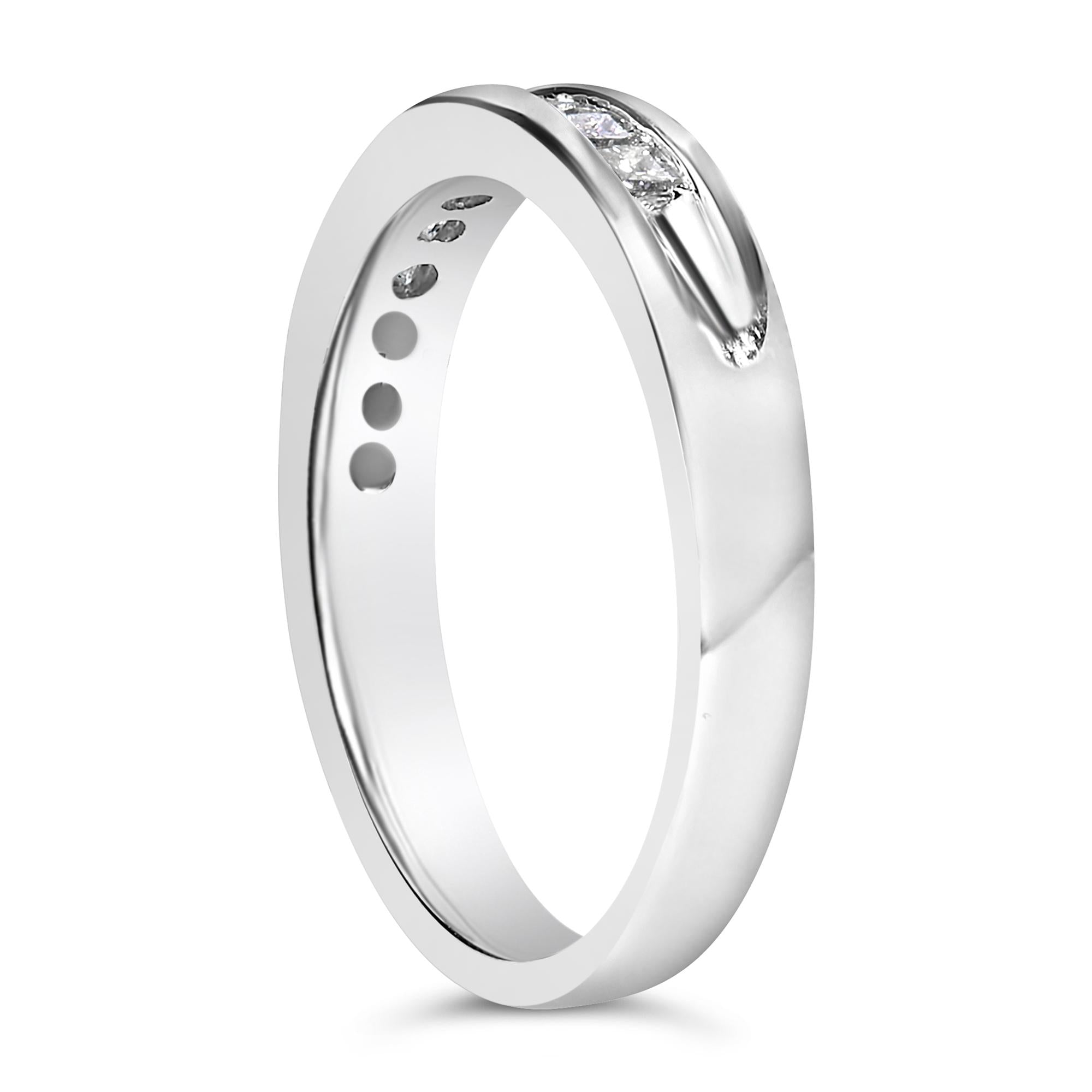 Silver ring with a polished finish and embedded small diamond, viewed at an angle on white background.