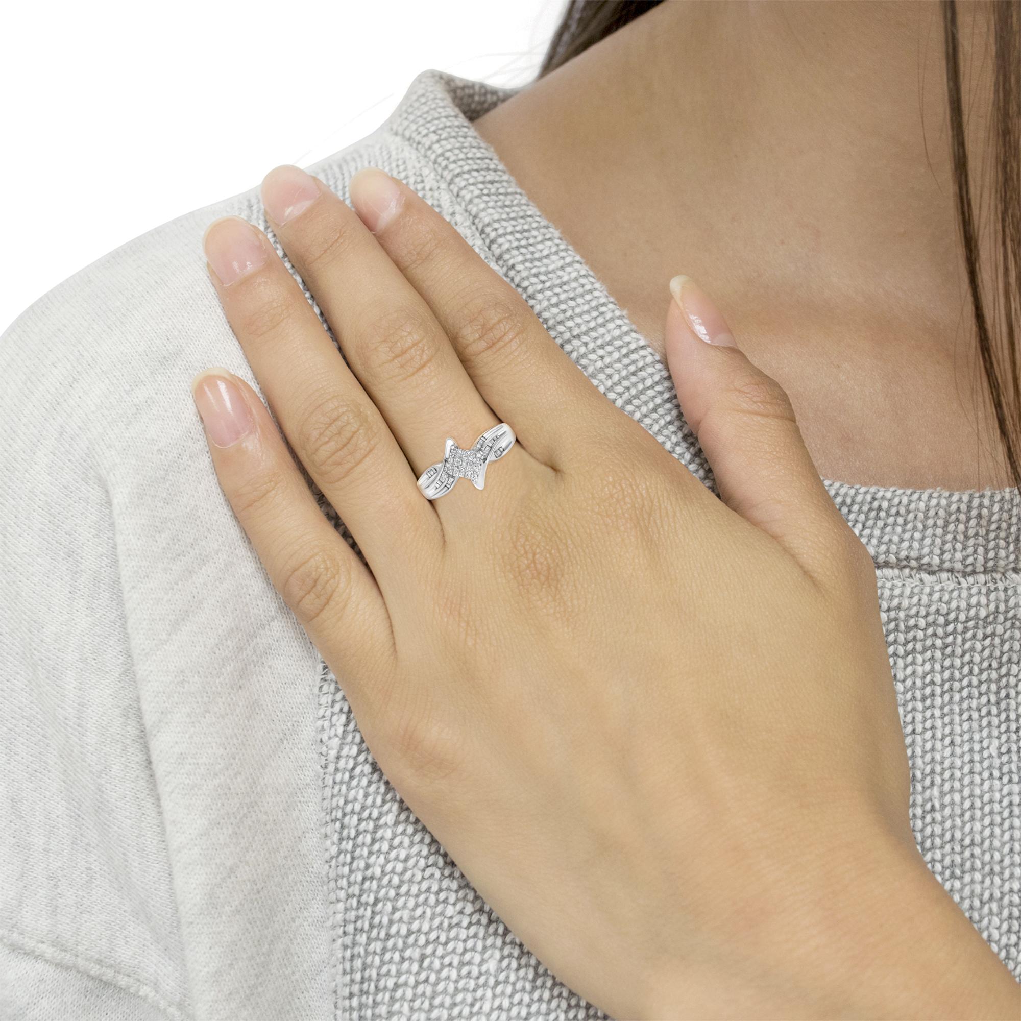 Close-up of a hand wearing a silver star ring on a knit gray sweater.