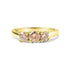 Gold ring with three round, peach-colored stones set in a row.