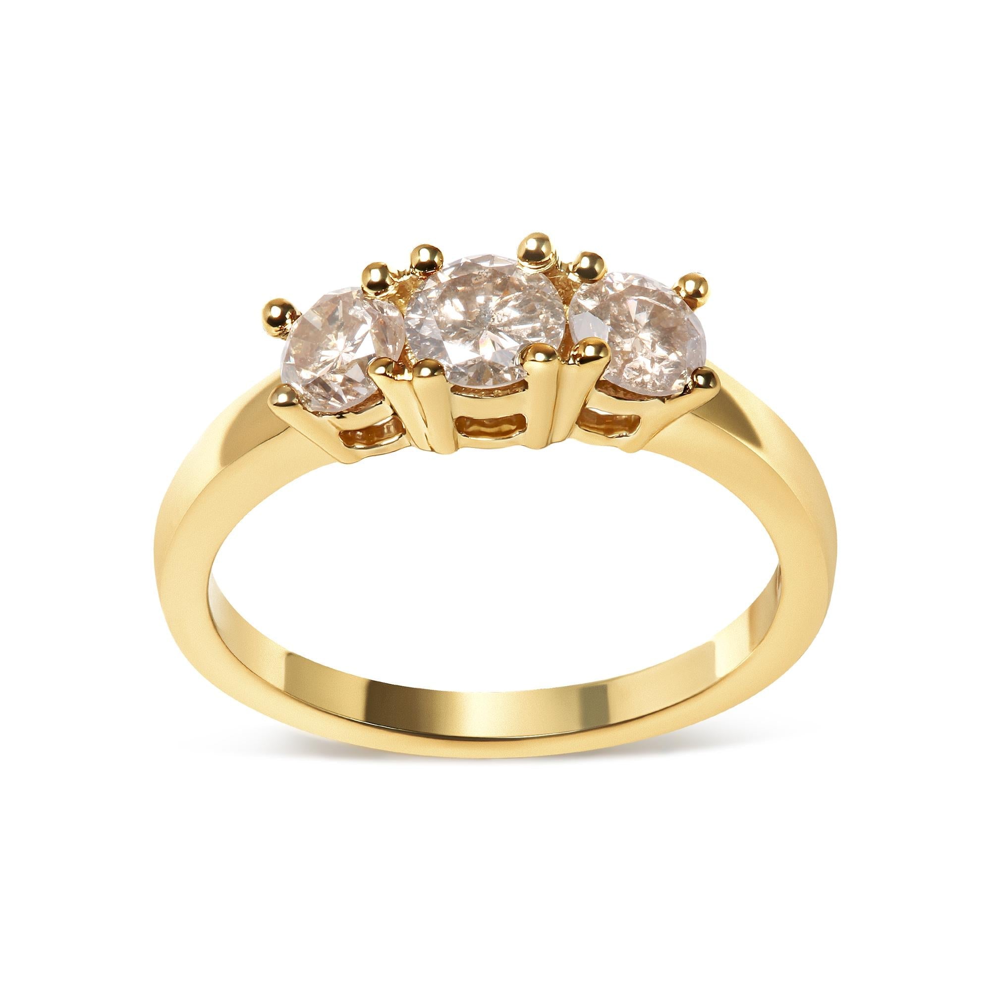 Gold ring with three round diamonds set in prongs, elegant and reflective design.