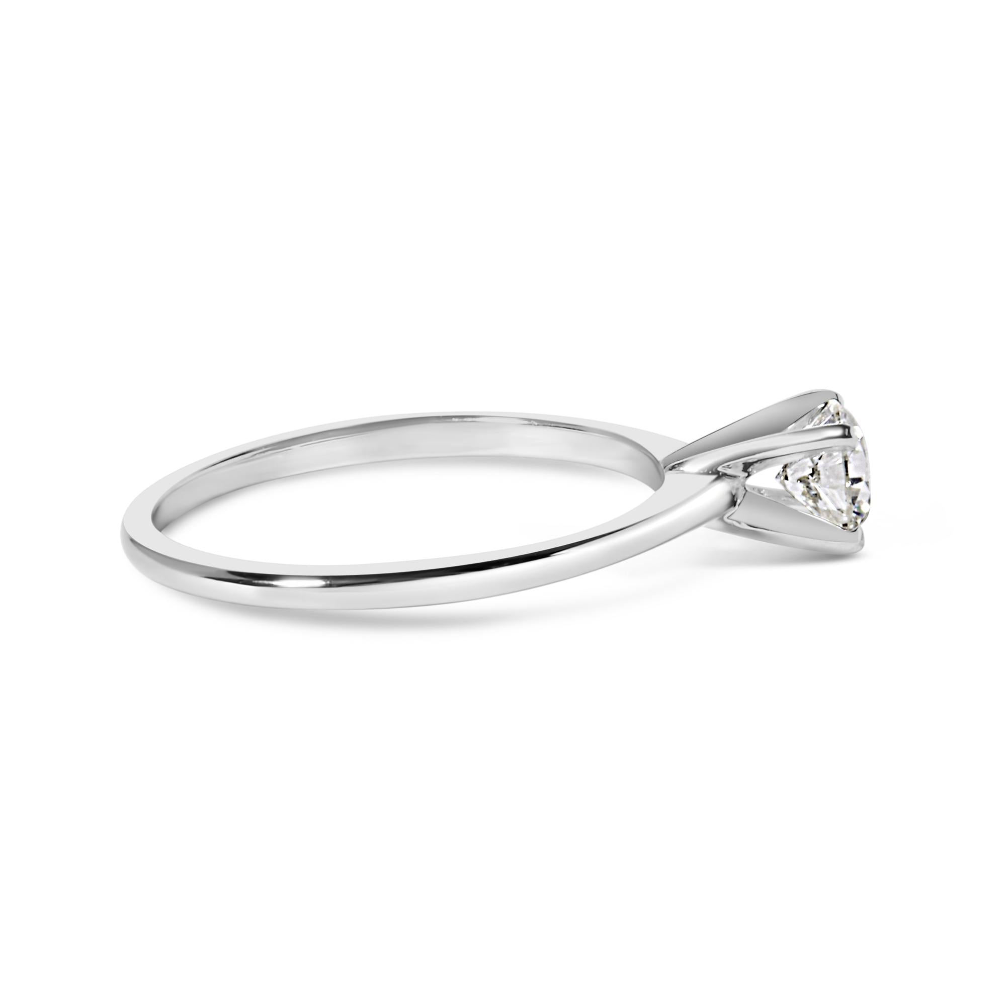 Silver ring with a triangular diamond in a solitaire setting on a white background.