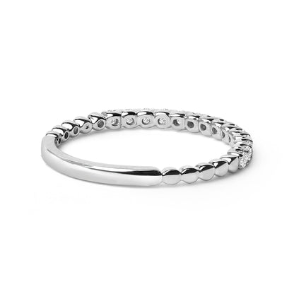 Silver bangle bracelet with a smooth curved design and small, round bead-like elements.