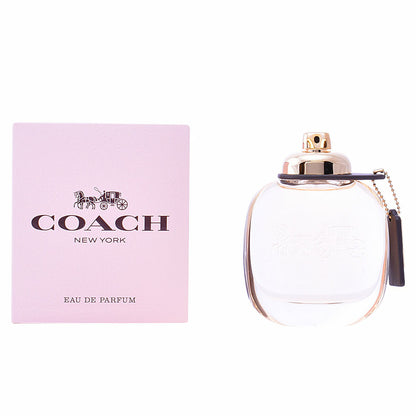 Pink box with "Coach New York" text beside a clear perfume bottle with gold accents.