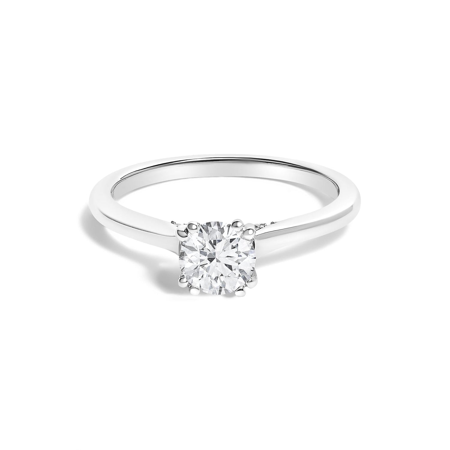 Silver ring with a round, sparkling diamond set in prongs, displayed on a white background.