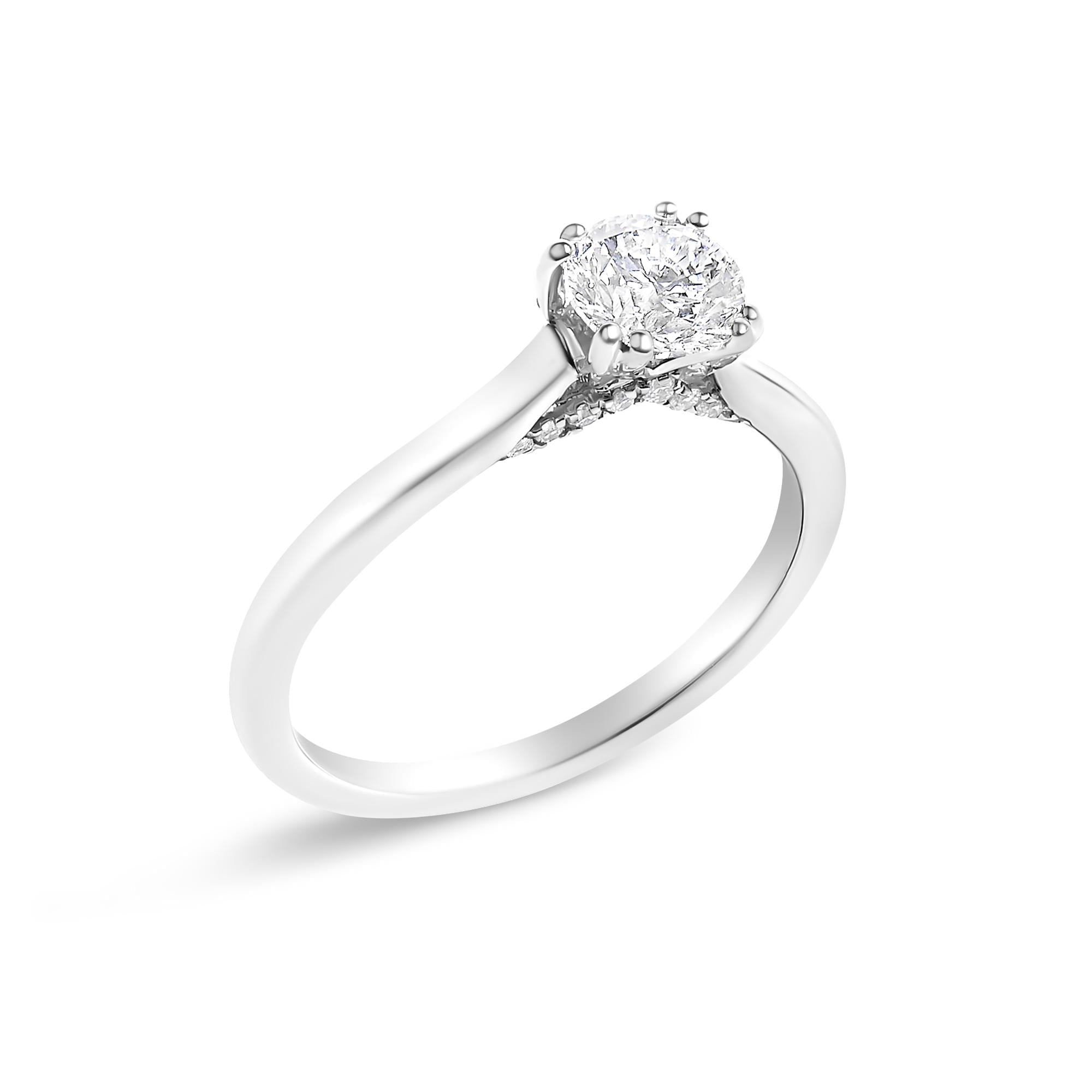 Silver ring with a large round diamond in a prong setting, twisted band featuring small accent stones.