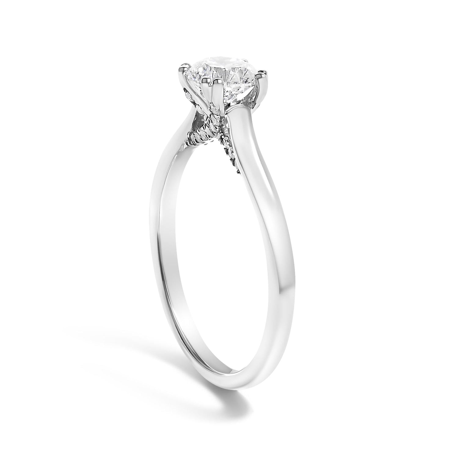 Silver engagement ring with a solitaire diamond on a pronged setting, sleek and shiny design.