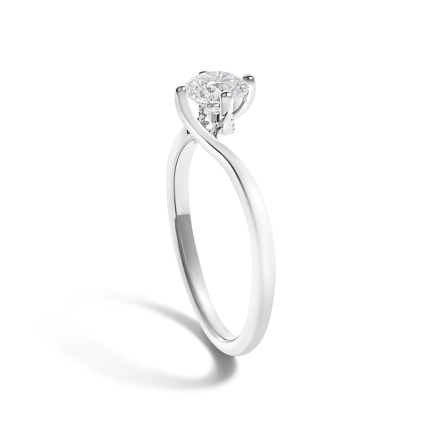 Silver ring with a round diamond set in a twisted prong setting, casting a soft shadow on white.