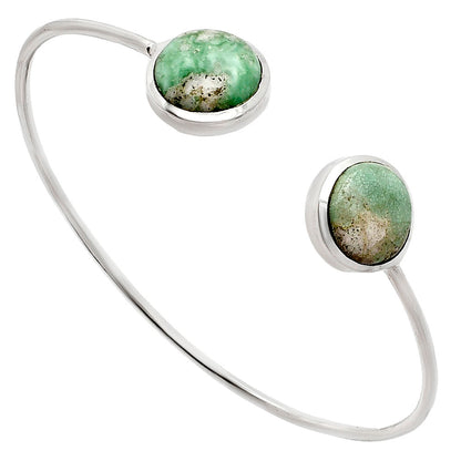 Silver open bangle bracelet with two round green stones at each end.