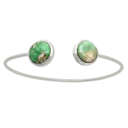 Silver bracelet with two round, mottled green stones on each open end.