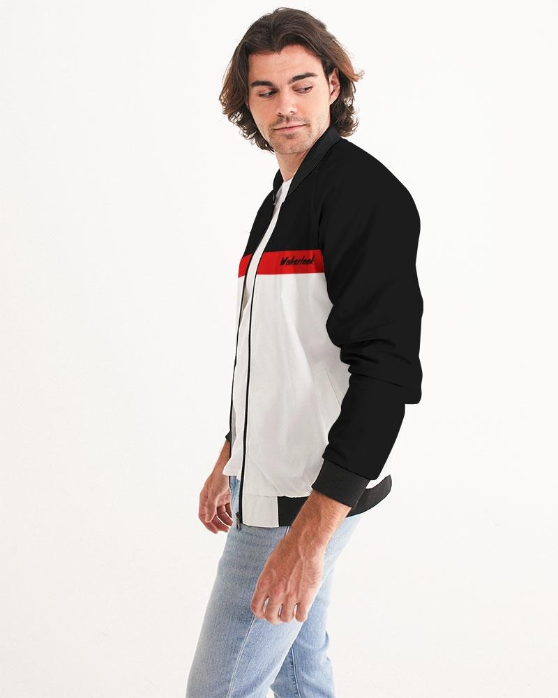 Man in black and white jacket with red stripe, light blue jeans, against a plain white background.
