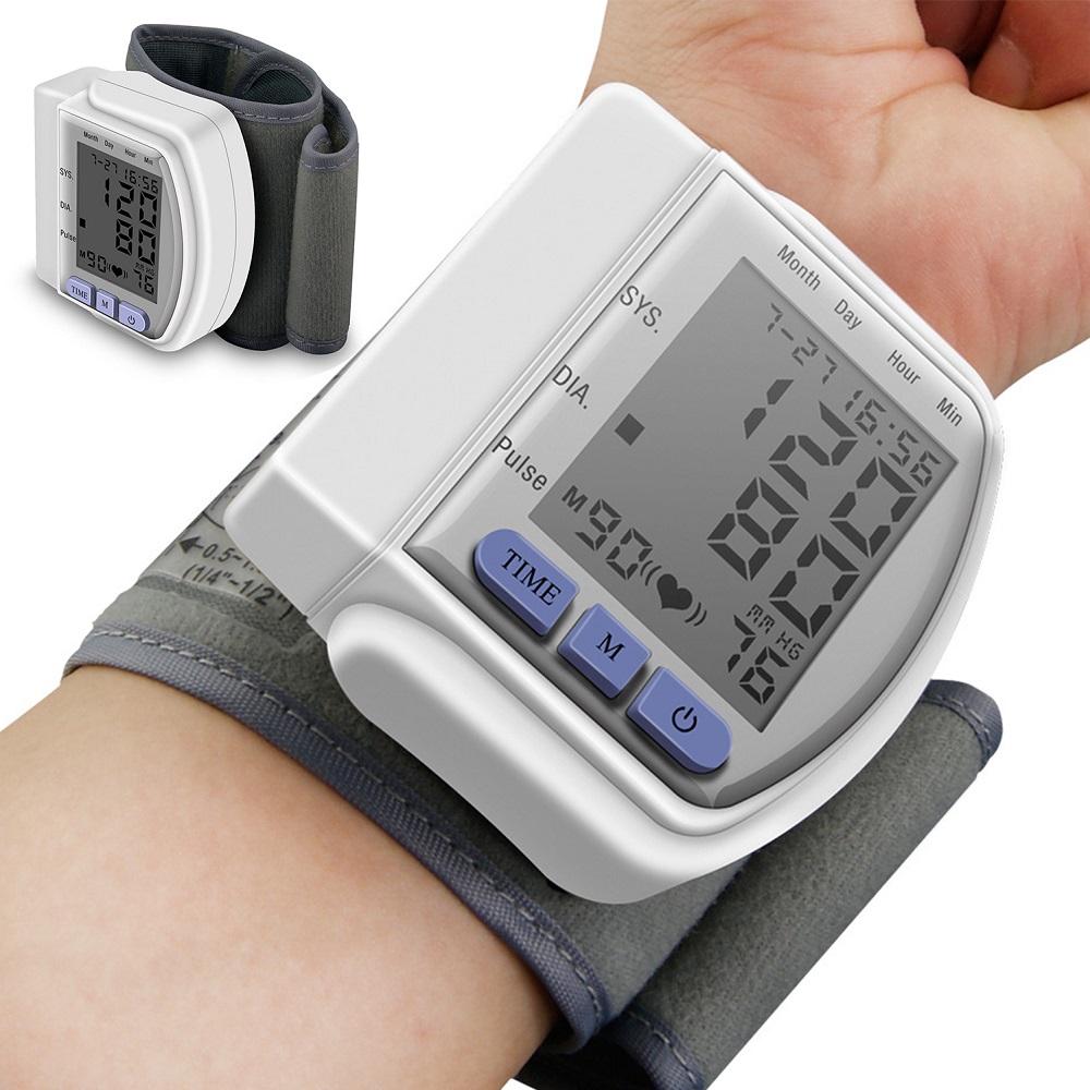 Digital wrist blood pressure monitor with grey cuff and blue buttons on a person&