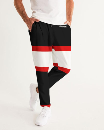 Man wearing black joggers with red and white horizontal stripes, white sneakers, and a white shirt.