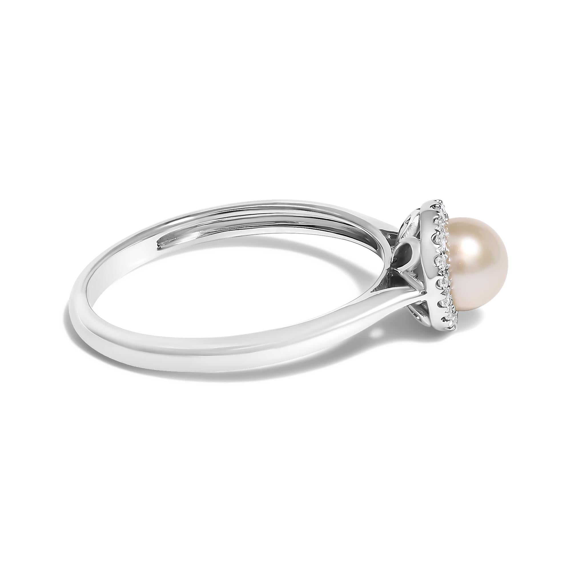 Silver ring with a round pearl center, encircled by small gemstones in a prong setting.
